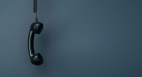 The handset of an old telephone off the hook